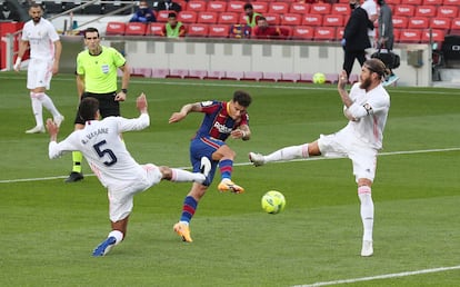 Coutinho remata ante Ramos y Varane en el Clásico.