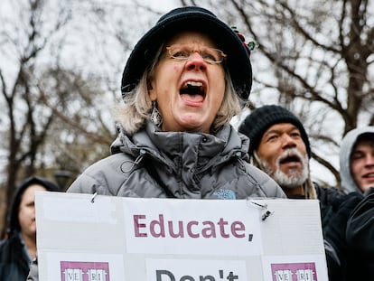 Cambridge, MA - April 12: A protester holds a sign reading "Educate, Don't Capitulate!!" featuring Harvard University shields during a rally at Cambridge Common. Allison Pingree, a Cambridge resident, joined hundreds demonstrating at the event partially sponsored by the Cambridge City Council to urge Harvard to resist President Trump's influence on the institution. (Photo by Erin Clark/The Boston Globe via Getty Images)