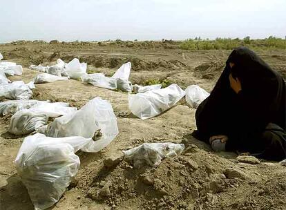 Una mujer llora junto a los restos de las personas que fueron sacadas en mayo de 2003 de la fosa común de Mahaweel, en el centro de Irak.