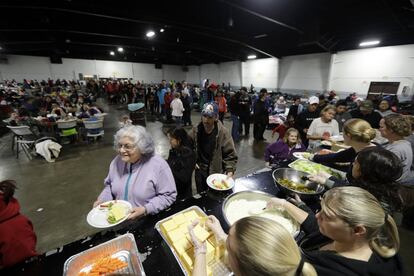 Un grupo de evacuados de las ciudades de los alrededores de la presa de Oroville hacen cola para recibir su cena en un refugio la noche del 13 de febrero. Las miles de personas a las que se les ha ordenado dejar sus casas no podrán regresar a sus hogares hasta que la erosión de la presa sea reparada.