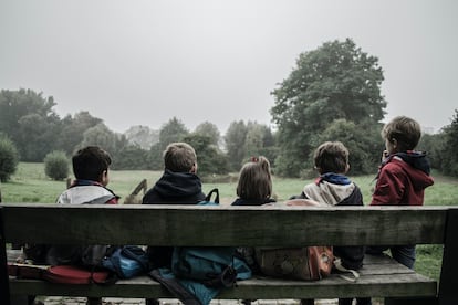 Cinco niños sentados miran al horizonte.