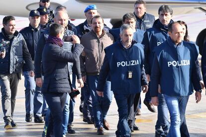 En el centro, Cesare Battisti, miembro del grupo terrorista italiano Proletarios Armados por el Comunismo (PAC), desembarca escoltado por varios policías italianos a su llegada al Aeropuerto Ciampino de Roma (Italia). Battisti, condenado por cuatro homicidios en este país en la década de 1970, llegó a Italia directamente desde Bolivia donde fue capturado tras huir hace un mes de Brasil. 