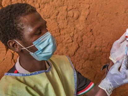 Un médico de una unidad móvil coloca la vacuna en una jeringuilla para administrarla a un niño en un asentamiento en Toro, Nigeria, en octubre de 2020.