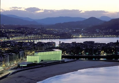 Vista de San Sebastián con el Kursaal iluminado junto a la playa.