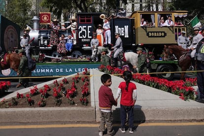 Niños observan un carro alegórico sobre Paseo de la Reforma, en Ciudad de México.