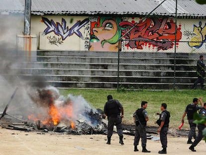 Agentes de la Policía brasileña, frente a los restos del helicóptero derribado por narcotraficantes en Rio de Janeiro.