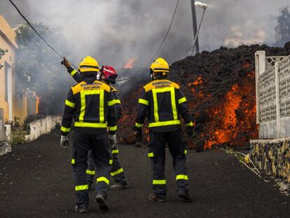 A group of firefighters face a lava flow in La Palma.