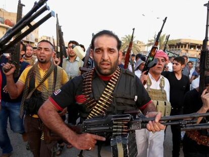 Combatientes chi&iacute;es empu&ntilde;an sus armas en Ciudad S&aacute;der, Bagdad.