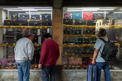 Tres hombres ven los productos en el aparador de una tienda en el centro de Ciudad de México, el pasado 18 de diciembre. 