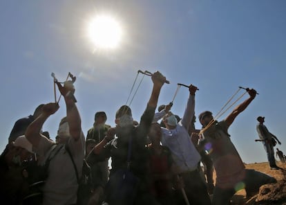 Manifestantes palestinos arrojan piedras contra las fuerzas israelíes durante los enfrentamientos en la Franja de Gaza.