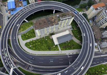 Un edificio residencial viejo rodeado por una carretera, el 18 de junio de 2015, en Guangzhou, provincia de Guangdong. El plan era demoler el edificio pero varios residentes se negaron a abandonarlo por no llegar a un acuerdo con las autoridades.