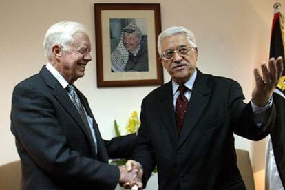 El ex presidente estadounidense Jimmy Carter saluda a Abu Mazen ayer en Ramala.