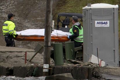 Un par de policías noruegos transportan un cadáver, el lunes en la isla de Utoya.