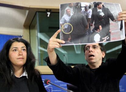 El director de cine iraní Molsen Makbalmaf, acompañado por Marjane Satrapi, muestra en Bruselas una fotografía
de milicianos armados.