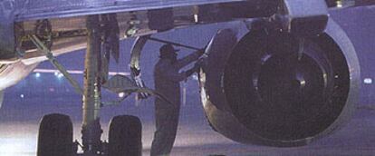 Un técnico de mantenimiento aeronáutico revisa un motor.