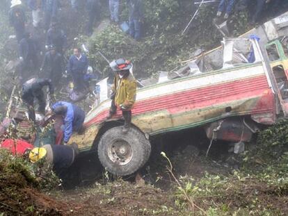 Bomberos y voluntarios retiran los cadáveres entre los restos del vehículo siniestrado.