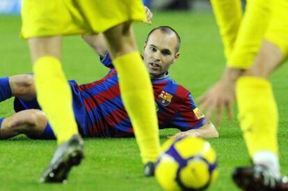 Iniesta, caído en el césped ante dos rivales en el Barça-Villarreal.