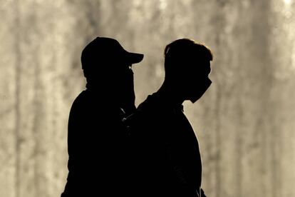 Dos hombres con mascarilla caminan juntos en Kansas City (EE UU).