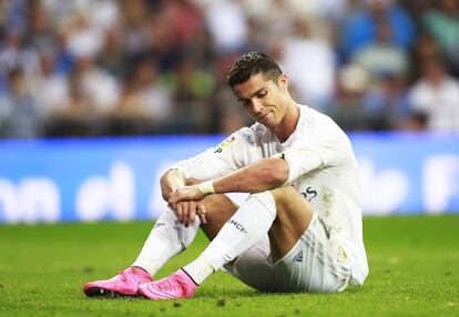 Cristiano Ronaldo sentado en el cesped del Santiago Bernabeu durante el encuentro contra el Málaga.