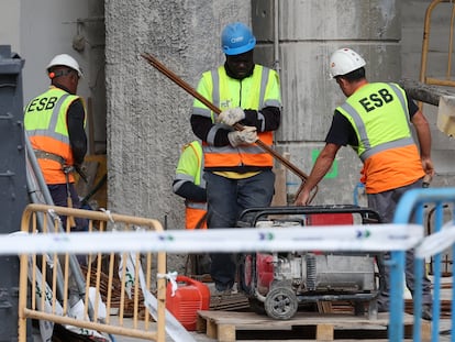 Un grupo de operarios en los alrededores del Santiago Bernabéu en Madrid, este miércoles.