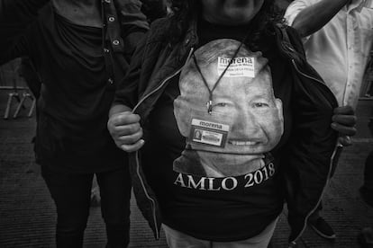 Una mujer muestra su playera con el rostro de AMLO.