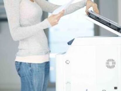Una mujer utilizando una fotocopiadora.