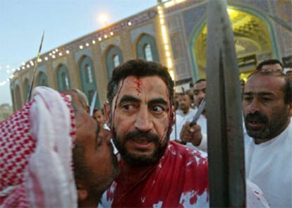 Un iraquí chií besa a otro con la cabeza abierta delante de la mezquita del imam Husein, en Kerbala, una de las ciudades santas.