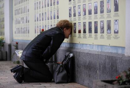 Una mujer llora frente a un mural con fotos de soldados que perdieron la vida en el conflicto en Ucrania del Este, este miércoles durante el Día de Recuerdo, en Kiev (Ucrania).
