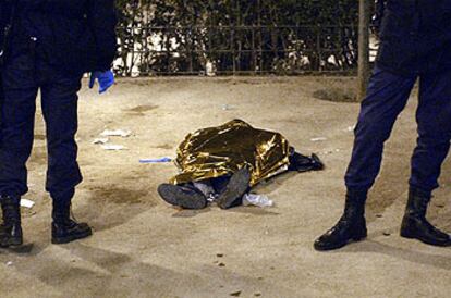 Dos agentes custodian el cadáver de un hombre asesinado este año en Madrid, en la plaza del Dos de Mayo.