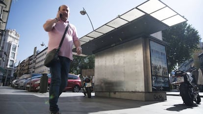 Un hombre pasa junto a un quiosco cerrado por la huelga de ruteros en Tirso de Molina (Madrid).