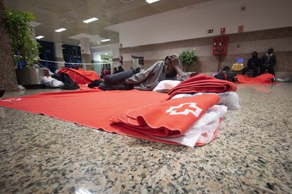 Los migrantes hacen camas improvisadas con mantas facilitadas por Cruz Roja en el suelo de la Estación Marítima de Algeciras.