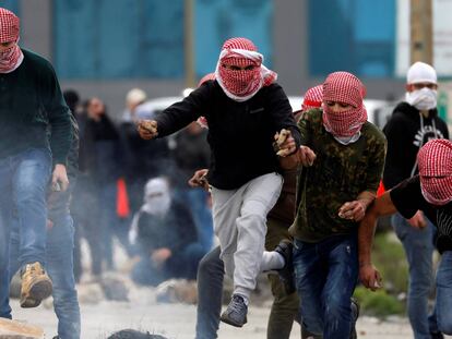 Un grupo de manifestantes palestinos corren durante los enfrentamientos con las fuerzas israelíes cerca del asentamiento judío de Beit El, en Ramala.