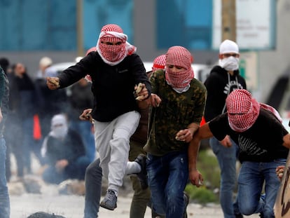 Un grupo de manifestantes palestinos corren durante los enfrentamientos con las fuerzas israelíes cerca del asentamiento judío de Beit El, en Ramala.