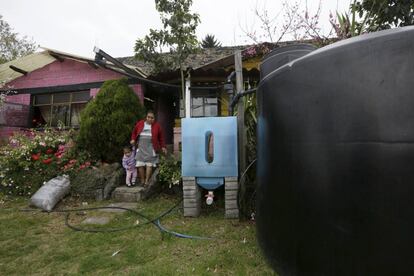 Una mujer y su nieta junto a un tanque que recoge el agua de lluvia para lavar y limpiar en San Miguel Xicalco, en las afueras de Ciudad de México.