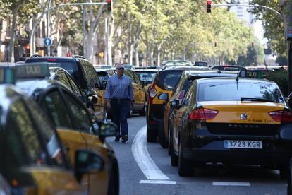 Un hombre camino entre los taxis parados durante la huelga de este lunes en Barcelona.