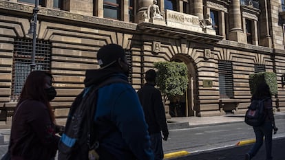 Un grupo de personas camina frente a la sede del Banco de México, en Ciudad de México.