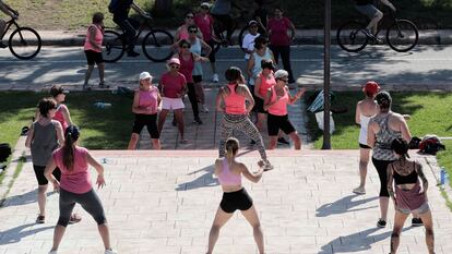 Un grupo de mujeres practica zumba en un parque.