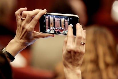 Una periodista toma una foto con su iPhone en una sesión del Parlamento de Cataluña el pasdo 28 de enero.