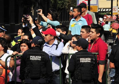 Un grupo de personas espera el paso del coche de Obama en una calle de M&eacute;xico.