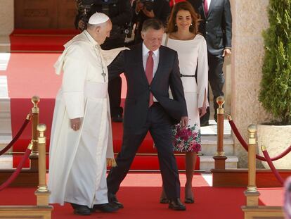 Abdullah de Jordania se dispone a ocupar su lugar entre el papa Francisco y la reina Rania, para presidir la ceremonia de bienvenida que han ofrecido al pont&iacute;fice en Amman.