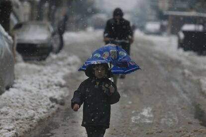 Un niño en una calle nevada de Douma.