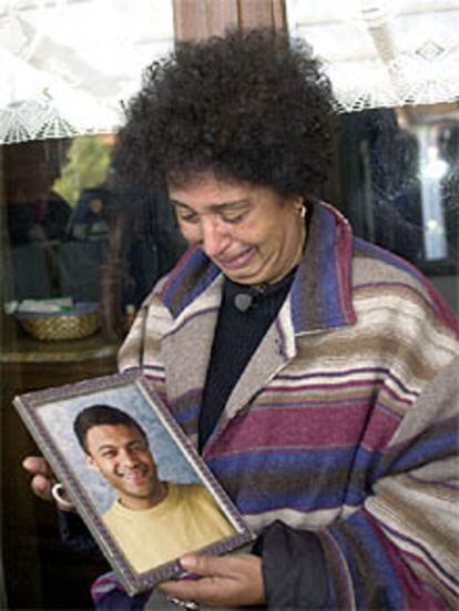 La madre de Mussaoui llora mientras contempla un retrato de su hijo.