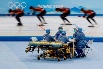 Personal médico con equipo de protección trabaja en una sesión de entrenamiento de patinaje de velocidad para los Juegos Olímpicos de Invierno de Pekín, que comenzarán el próximo viernes 4 de febrero.