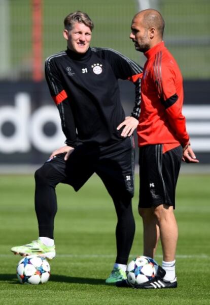 Guardiola charla con Schweinsteiger en el entrenamiento.