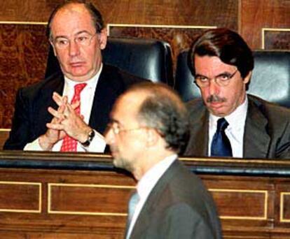 Cristóbal Montoro pasa frente a José María Aznar y Rodrigo Rato en el Congreso de los Diputados.