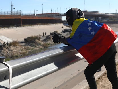 A Venezuelan migrant looks towards the United States wrapped in his country's flag as he waits for the opportunity to cross from Ciudad Juárez, Chihuahua state, Mexico, in December 2022.