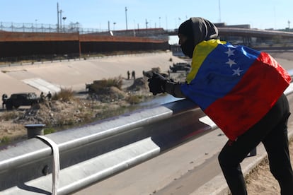 El migrante venezolano Alejandro Rojas, de 22 años, mira hacia Estados Unidos envuelto en la bandera de su país mientras espera la oportunidad de cruzar desde Ciudad Juárez, México.