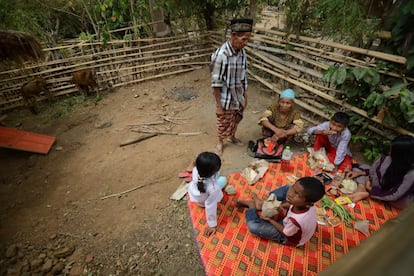 Una familia come en las afueras de su casa tras los da?os ocasionados en la vivienda por el terremoto en la isla de Lombok (Indonesia).