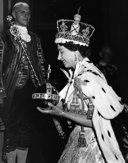 Queen Elizabeth II wearing the Imperial state Crown and carrying the Orb and sceptre, leaving the state coach and entering Buckingham Palace, after the coronation.  