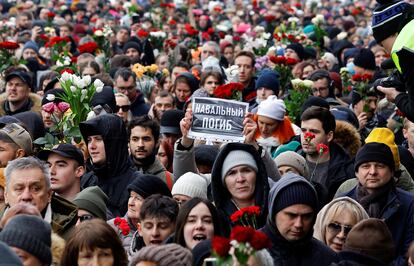 Un ciudadano ruso muestra un cartel con el lema "Navalni murió" durante el funeral en el cementerio.